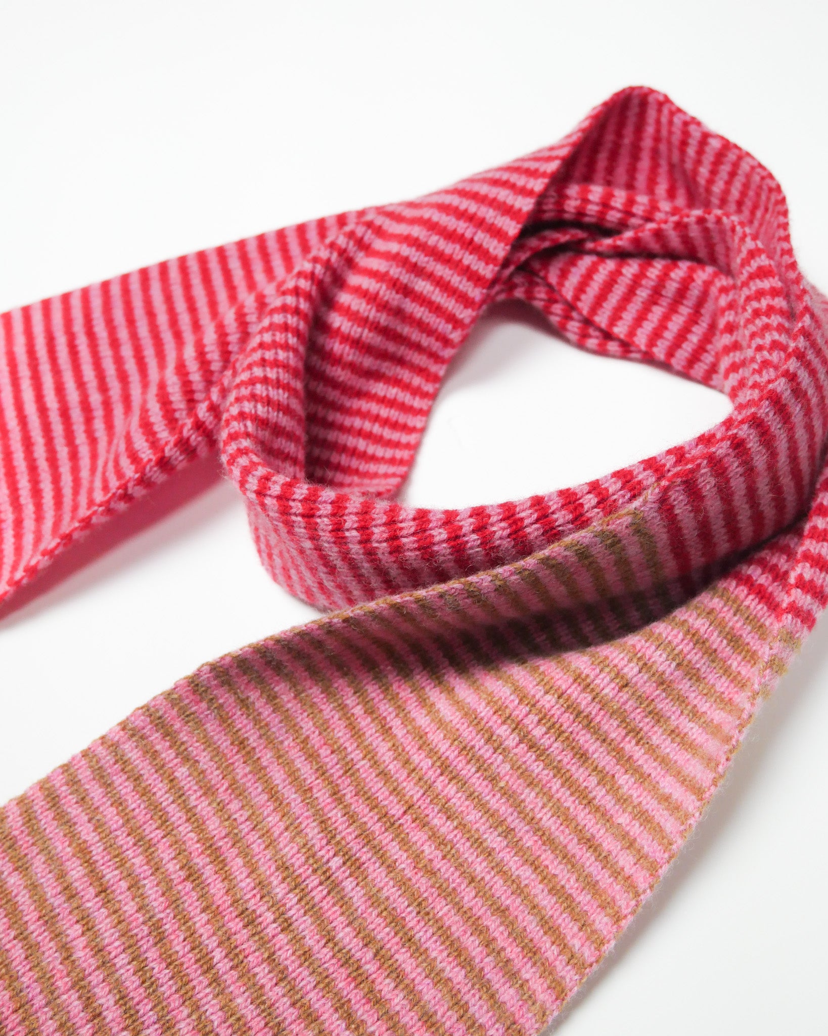 Red, pink and brown striped scarf on a white background.