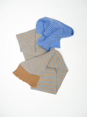 Folded fabric with blue and brown stripes on a white background